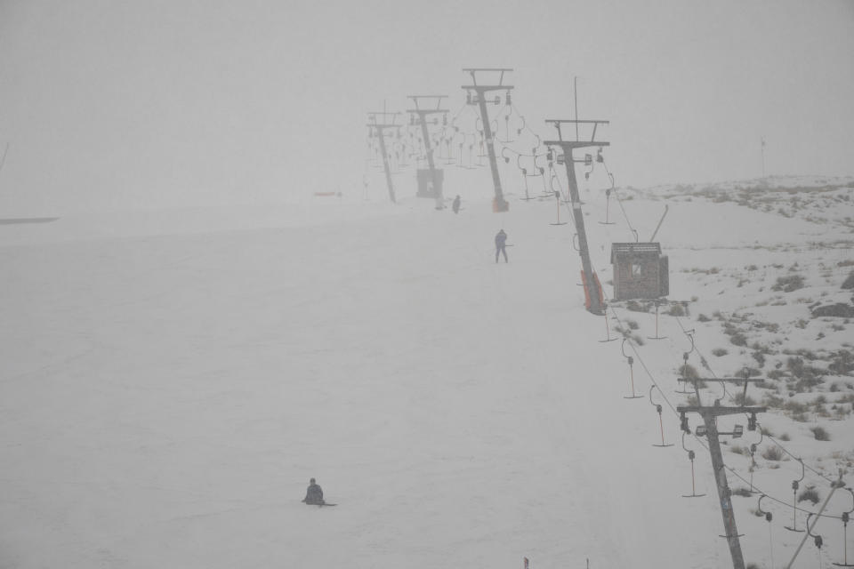 Few skiers brave the fog and falling snow at the Afriski ski resort near Butha-Buthe, Lesotho, Saturday July 30, 2022. While millions across Europe sweat through a summer of record-breaking heat, Afriski in the Maluti Mountains is Africa's only operating ski resort south of the equator. It draws people from neighboring South Africa and further afield by offering a unique experience to go skiing in southern Africa. (AP Photo/Jerome Delay)