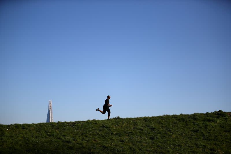 A runner is seen in Burgess Park, as the spread of coronavirus disease (COVID-19) continues in London