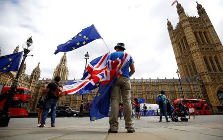 FILE PHOTO: Anti-Brexit demonstrators wave EU and Union flags opposite the Houses of Parliament, in London, Britain, June 19, 2018. REUTERS/Henry Nicholls/File Photo