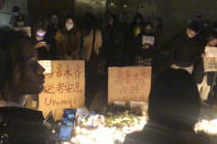 In this photo obtained by The Associated Press, demonstrators stand by protest signs in Shanghai on Saturday, Nov. 26, 2022. Protests against China’s restrictive COVID measures appeared in a number of cities Saturday night, in displays of public defiance fanned by anger over a deadly fire in the western Xinjiang region. (AP Photo)