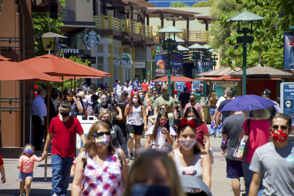 FILE - In this July 9, 2020, file photo, guests at the Disneyland Resort visit the Downtown Disney District in Anaheim, Calif. Gov. Gavin Newsom has relaxed coronavirus restrictions in five more counties. The announcement on Tuesday, Sept. 8, 2020, means the state has now eased restrictions for more than 8 million people living in three of the state's most populous counties — San Diego, Orange, and Santa Clara. (Jeff Gritchen/The Orange County Register via AP, File)