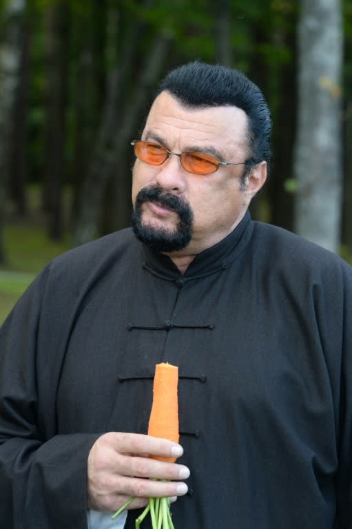 US actor Steven Seagal (R) eats a carrot during his meeting with Belarus President at his residence of Drozdy, outside Minsk, on August 24, 2016