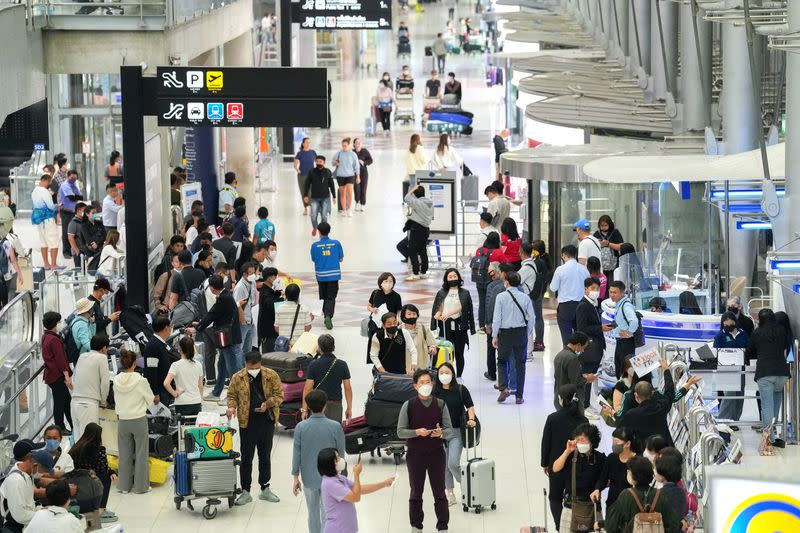 FILE PHOTO: Tourists wait to check in for flights at Bangkok's Suvarnabhumi airport