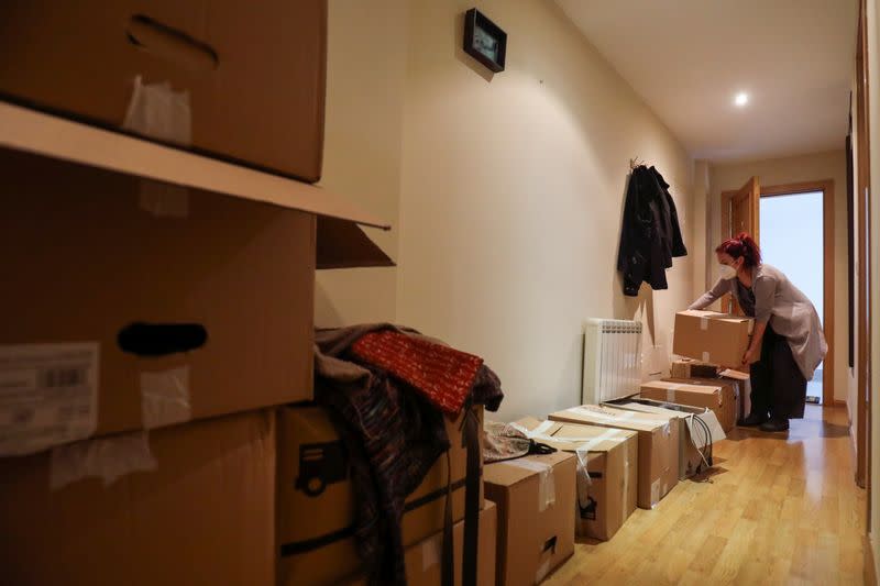 Ines Alcolea places moving boxes in her new rented apartment in Fuensalida