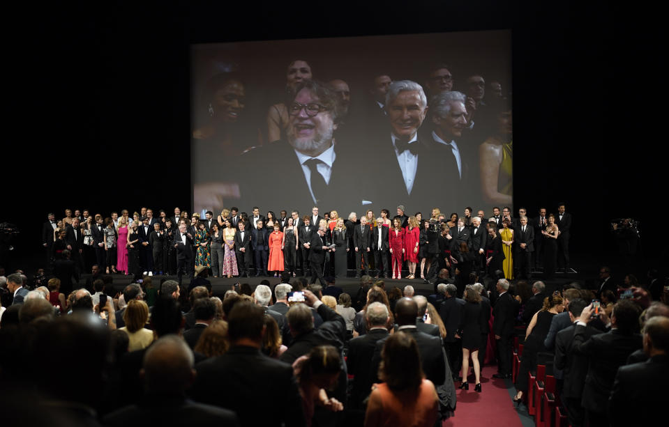 Guillermo del Toro, left, and Claude Lelouch appear on screen as they and other film industry professionals gather to celebrate the 75th anniversary ceremony of the Cannes international film festival, Cannes, southern France, Tuesday, May 24, 2022. (AP Photo/Daniel Cole)