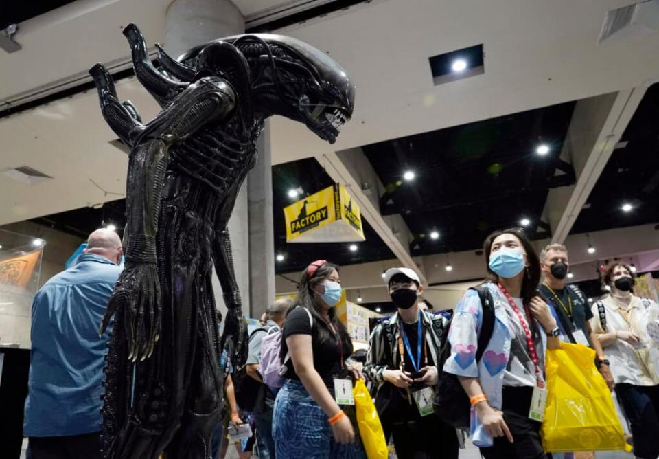 A Comic-Con attendee walks past a life-size model of the creature from the “Alien” movie franchise during Preview Night at the 2022 Comic-Con International at the San Diego Convention Center, Wednesday, July 20, 2022, in San Diego. (AP Photo/Chris Pizzello)