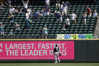 Oakland Athletics right fielder Seth Brown watches a home run by Seattle Mariners' Donovan Walton drop into the stands among fans during the fourth inning of a baseball game, Monday, May 31, 2021, in Seattle. (AP Photo/John Froschauer)