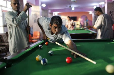 Iraqi Shi'ite men play pool in Sadr City in Baghdad in this April 29, 2014 file photo. REUTERS/Ahmed Jadallah/Files