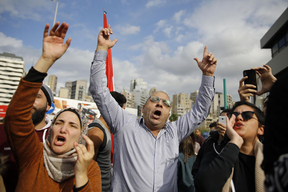 Protesters chant slogans during ongoing protests against the Lebanese political class, in front of a Finance Ministry building in Beirut, Lebanon, Friday, Nov. 29, 2019. Protesters have been holding demonstrations since Oct. 17 demanding an end to widespread corruption and mismanagement by the political class that has ruled the country for three decades. (AP Photo/Bilal Hussein)