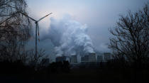 FILE PHOTO: Water vapour rises from the cooling towers of the Jaenschwalde lignite-fired power plant of Lausitz Energie Bergbau AG (LEAG) beside a wind turbine in Jaenschwalde