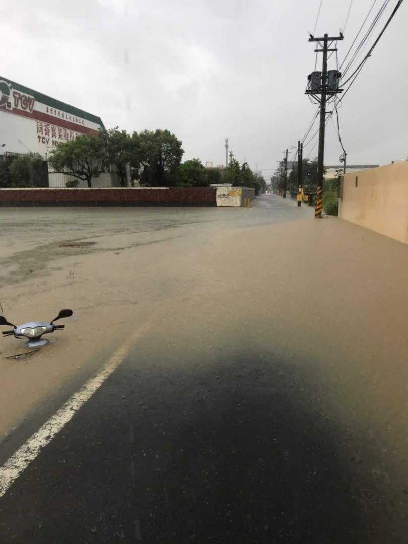 大寮地區也淹水嚴重分不清是道路還是水溝，一名騎士將機車不慎騎進低窪區動彈不得。（圖／翻攝畫面）