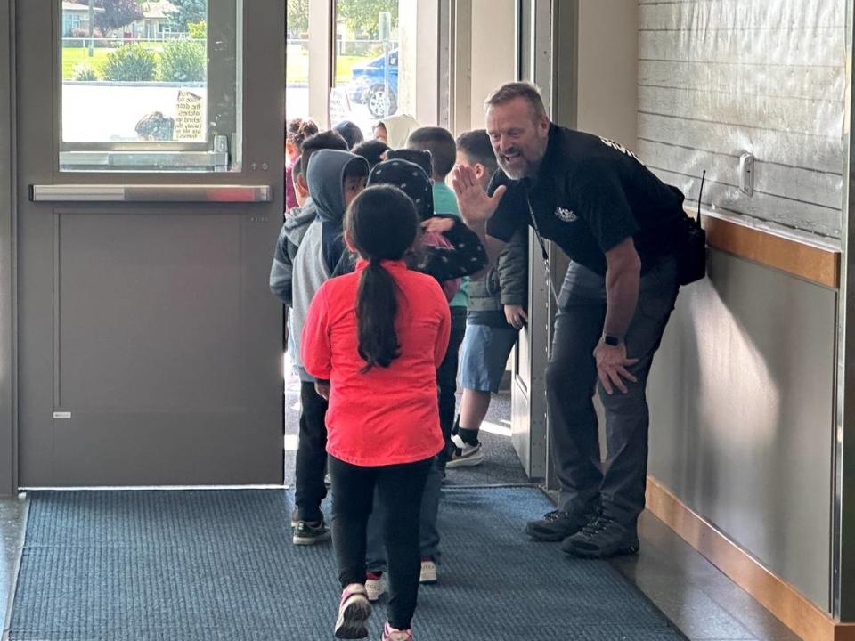 Former Kennewick police commander Scott Child greets kids at Amistad Elementary on the first day of school.
