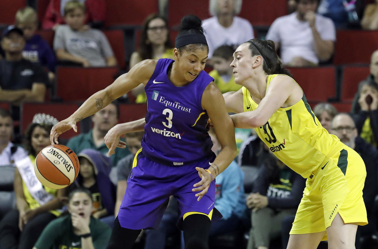 Seattle Storm's Breanna Stewart, right, is unsuccessful as she tries to reach around to grab the ball from Los Angeles Sparks' Candace Parker in the second half of a WNBA basketball game Tuesday, July 10, 2018, in Seattle. The Sparks won in overtime 77-75. (AP Photo/Elaine Thompson)