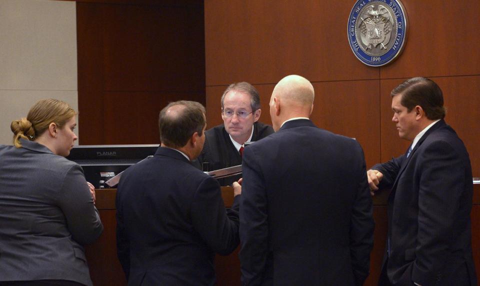 Defense attorneys Haylee Mills, left, Randall Marshall, second from left, Deputy Weber County prosecuting attorney Chris Saw, second from right, and Weber County Attorney Dee Smith, right, speak with Judge Scott Hadley at Eric Millerberg's trail, Wednesday, Feb. 12, 2014, in Ogden, Utah. Millerberg has been charged with injecting his 16-year-old baby sitter, Alexis Rasmussen, with a fatal dose of heroin and methamphetamine, then taking his wife and infant daughter along to dump Rasmussen's body near a river. (AP Photo/The Salt Lake Tribune, Leah Hogsten, Pool)