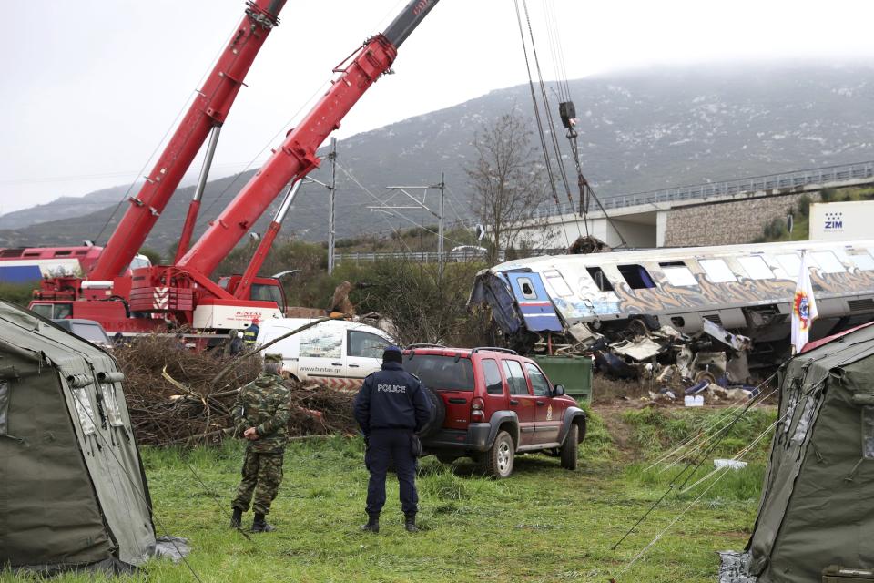 Cranes remove debris after a collision in Tempe, about 376 kilometres (235 miles) north of Athens, near Larissa city, Greece, Thursday, March 2, 2023. Emergency workers are searching for survivors and bodies after a passenger train and a freight train crashed head-on in Tempe, central Greece just before midnight Tuesday. It was the country's deadliest rail crash on record. (AP Photo/Vaggelis Kousioras)