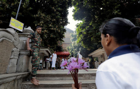 An army soldier stands guard at an entrance of the Kelaniya Buddhist temple during Vesak Day, commemorating the birth, enlightenment and death of Buddha, in Colombo, Sri Lanka May 18, 2019. REUTERS/Dinuka Liyanawatte