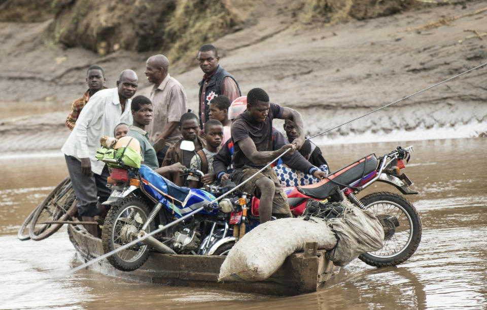 Men transport their salvaged belongings in Chiradzulu, southern Malawi, Friday March 17, 2023. Authorities are still getting to grips with the scale of Cyclone Freddy's destruction in Malawi and Mozambique since late Saturday, with over 300 people confirmed dead and several hundreds still displaced or missing. (AP Photo/Thoko Chikondi)