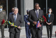 Ukrainian Defense Minister Andriy Taran, left, and U.S. Defense Secretary Lloyd Austin lay flowers on a monument commemorating fallen defenders in Kyiv, Ukraine, Tuesday, Oct. 19, 2021. (Gleb Garanich/Pool Photo via AP)