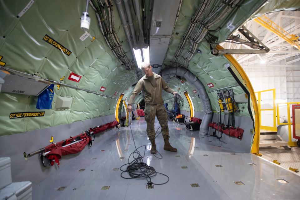 Hunter Willard, crew chief with the 190th Air Refueling Wing of the Kansas Air National Guard, winds up cords in the fuselage of a KC-135 Thursday morning. The presence of the 190th is considered a key factor in attracting companies needing to convert passenger jets into freight ones.