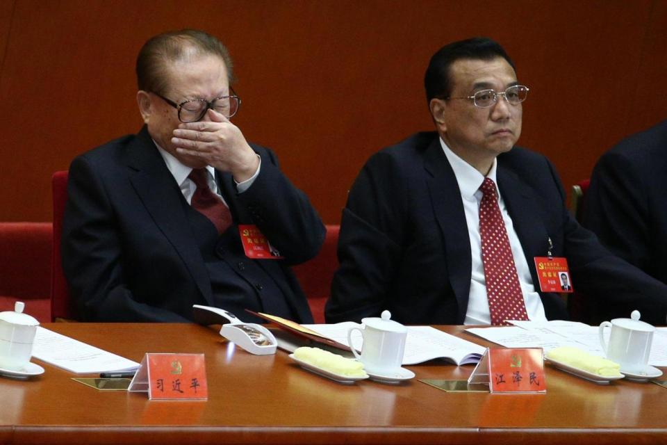 Former Chinese President Jiang Zemin, left, stifles a yawn beside Chinese Premier Li Keqiang at the Congress (EPA)