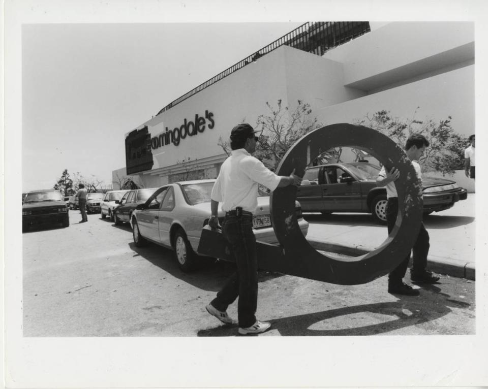 File photo shows work crews carrying a letter to help repair the former Bloomingdale’s sign at The Falls outdoor shopping mall after Hurricane Andrew damaged the South Miami-Dade attraction and surrounding neighborhoods in August 1992. In August 2023, a Life Time Fitness resort-style gym center replaced the Bloomingdale’s, which had been closed since March 2020. Miami Herald file