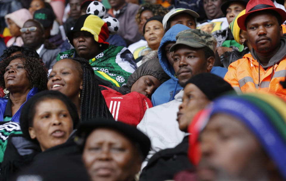 A mourner sleeps during the memorial service for former South African president Nelson Mandela at the FNB Stadium in Soweto near Johannesburg, Tuesday, Dec. 10, 2013. (AP Photo/Markus Schreiber)