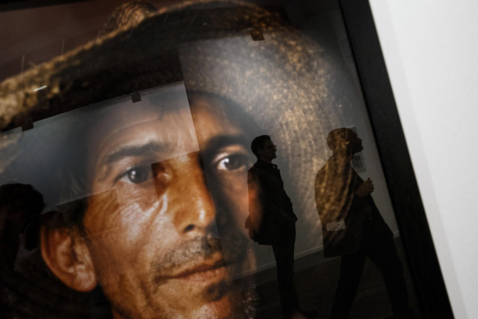 <p>Visitors are reflected in a framed picture by Andres Serrano at the ARCO International Contemporary Art Fair in Madrid, Feb. 22, 2017. (Photo: Daniel Ochoa de Olza/AP) </p>