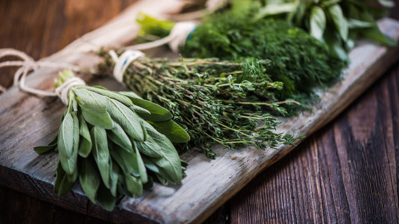 bunches of fresh herbs on chopping board