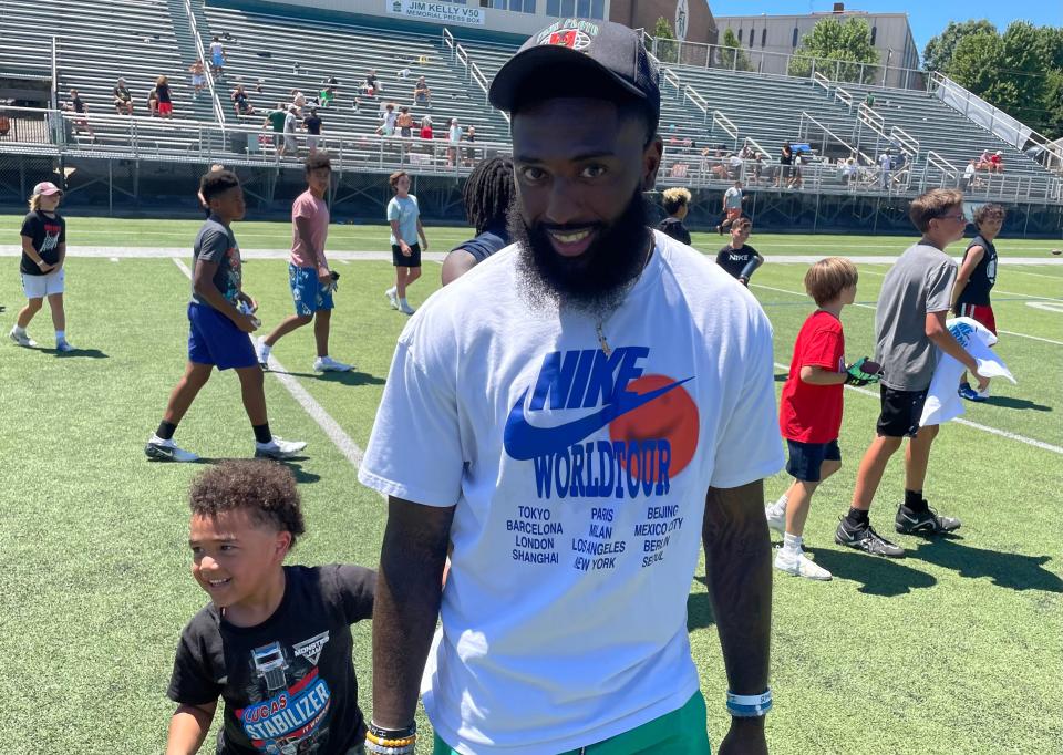 Indianapolis Colts wide receiver Parris Campbell walks on the field at his alma mater, St. Vincent-St. Mary High School, with his son, Kai, during a Nike Football Skills Camp on Friday in Akron.