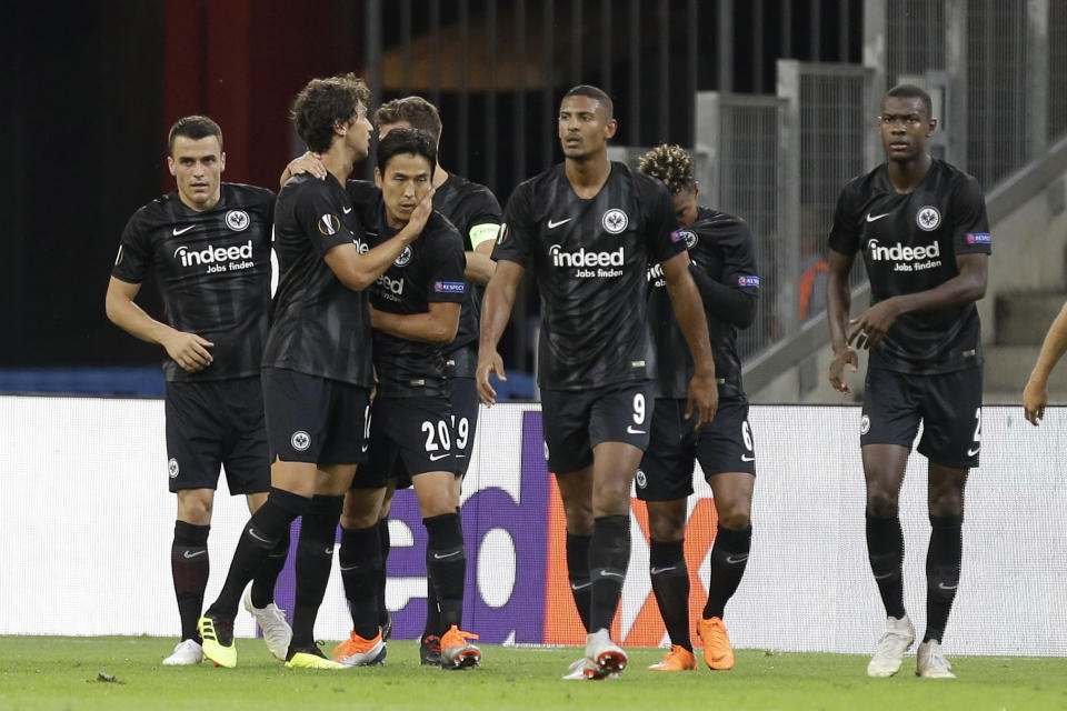 Eintracht Frankfurt's Lucas Torro, second left, reacts with Makoto Hasebe (20) and teammates after scoring his side first goal during the Europa League, group H soccer match between Marseille and Eintracht Frankfurt played behind closed doors at the Velodrome stadium in Marseille, southern France, Thursday Sept. 20, 2018. (AP Photo/Claude Paris)