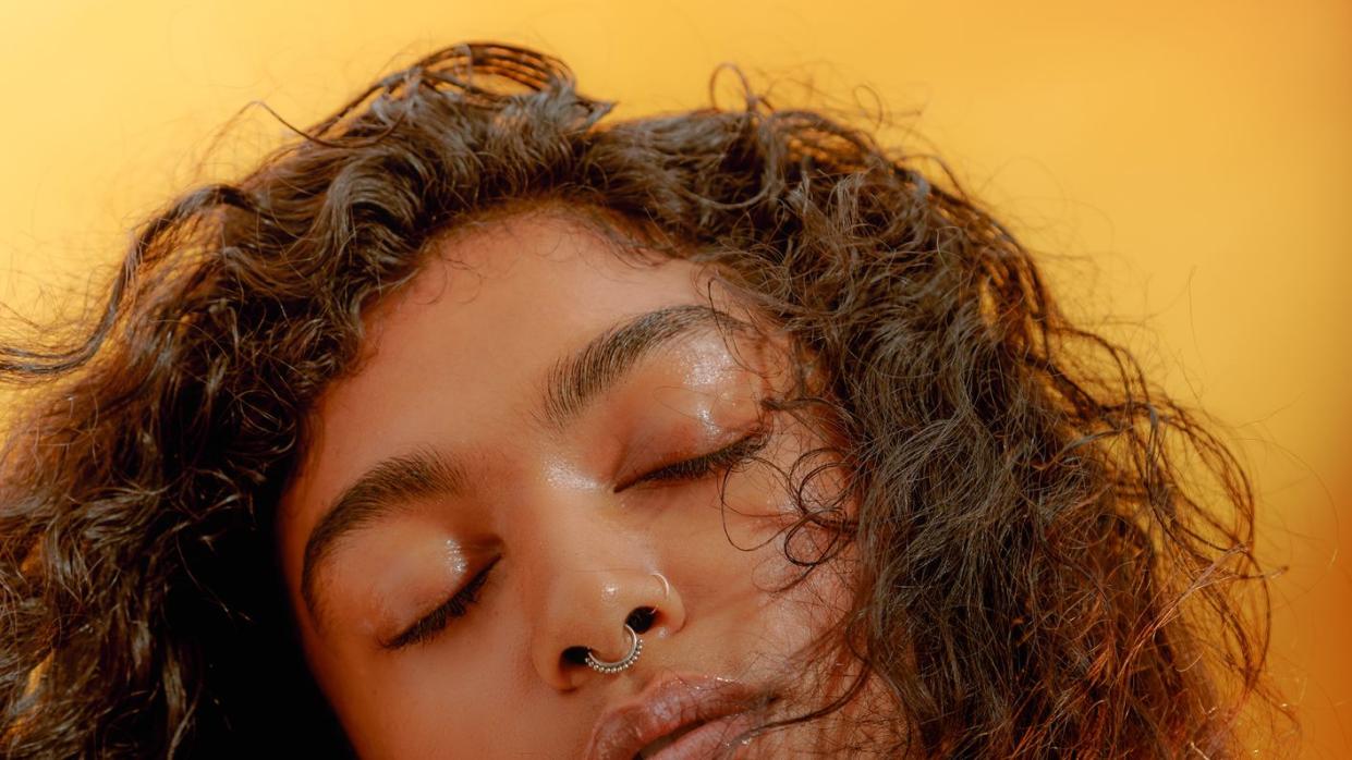 portrait of a young confident woman closing her eyes with windswept hair