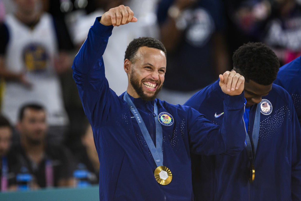 PARIS, FRANCE - AUGUST 11: Gold medalist Stephen Curry of Team United States celebrate on the podium during the Men's basketball medal ceremony on day fifteen of the Olympic Games Paris 2024 at the Bercy Arena on August 11, 2024 in Paris, France. (Photo by Tom Weller/VOIGT/GettyImages)