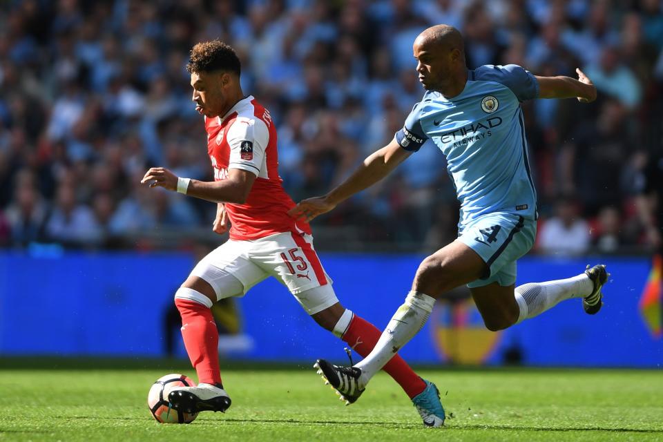 Alex Oxlade-Chamberlain of Arsenal and Vincent Kompany of Manchester City compete for the ball during the Emirates FA Cup Semi-Final match between Arsenal and Manchester City at Wembley Stadium