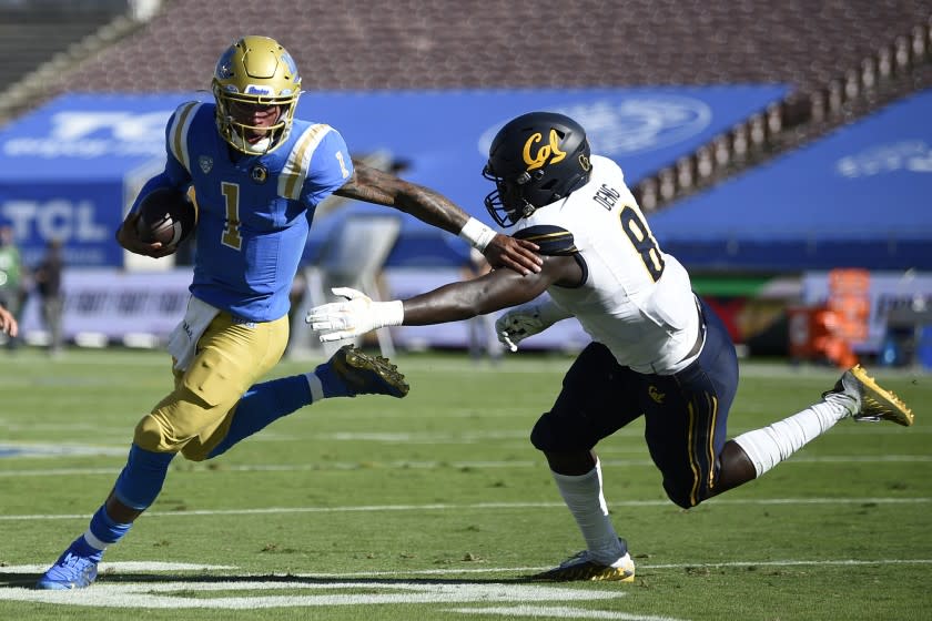 UCLA quarterback Dorian Thompson-Robinson, left, runs the ball while California linebacker Kuony Deng.