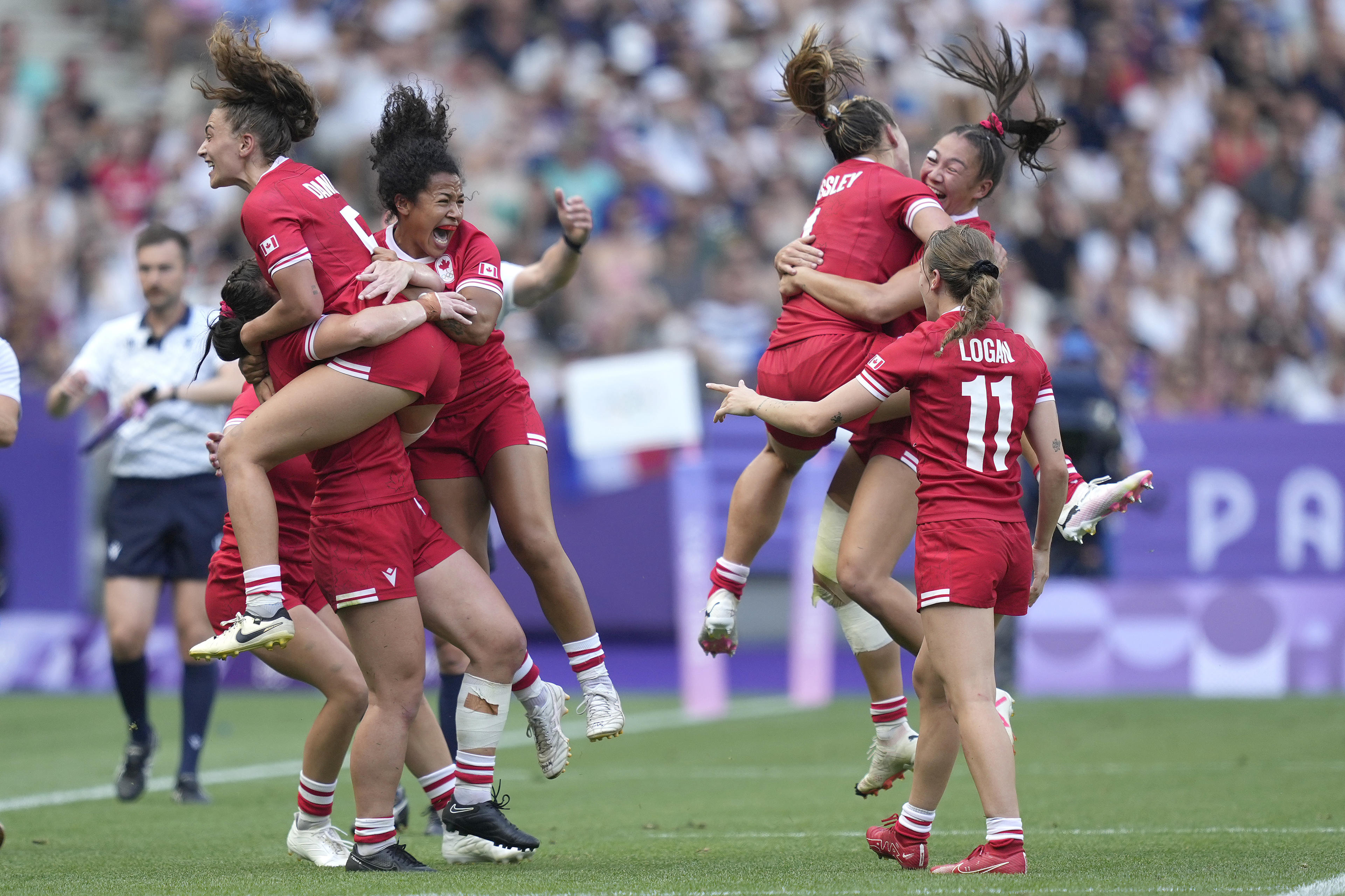 Members of the Canadian team celebrate after winning the women's semifinal Rugby Sevens match between Canada and Australia at the 2024 Summer Olympics, in the Stade de France, in Saint-Denis, France, Tuesday, July 30, 2024. Canada won the game 21-12. (AP Photo/Tsvangirayi Mukwazhi)