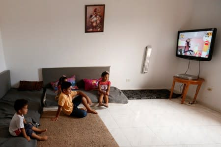 Displaced Libyan children who fled their home after clashes, watch TV at a hotel used as a shelter in Tajura neighborhood, east of Tripoli