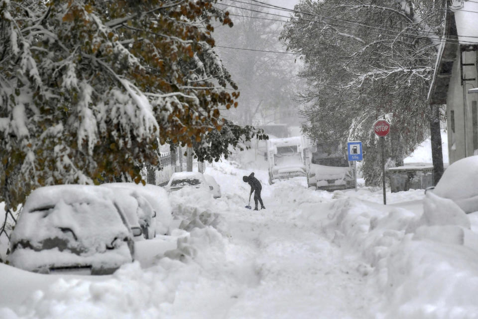 A man shovels snow in town of Isperih, Northeast Bulgaria, Sunday, Nov. 26, 2023. Bulgaria's government declared a state of emergency in large parts of the Balkan country after heavy snow and powerful winds caused power outages, closed roads, traffic accidents and travel delays. (AP Photo/ Bulgarian News Agency)