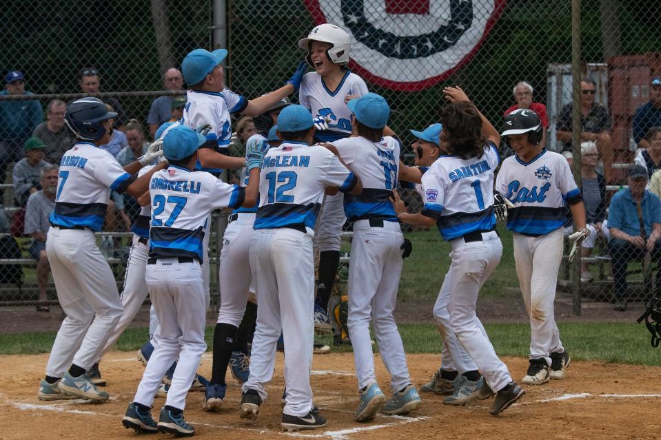 Toms River East's Carson Frazier (#10 in the center) is greeted at plate after hitting a three-run homer. Toms River East defeats Hillsdale 8-4 in the 2021 NJ Little League State Tournament Championship game in Cherry Hill N.J. on August 1, 2021.