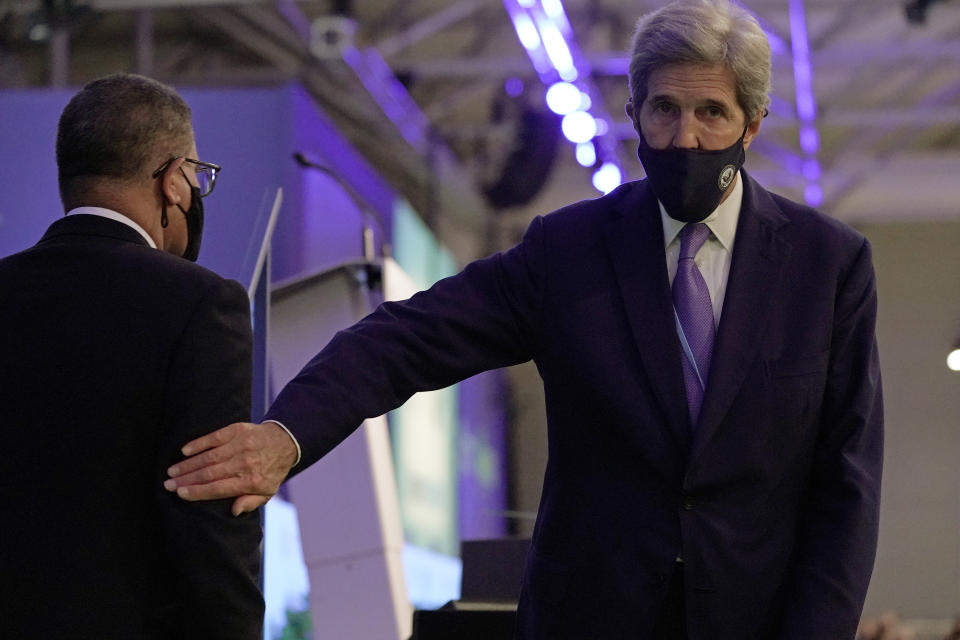 John Kerry, United States Special Presidential Envoy for Climate, right, touches the arm of Alok Sharma President of the COP26 summit during a stocktaking plenary session at the COP26 U.N. Climate Summit in Glasgow, Scotland, Saturday, Nov. 13, 2021. Going into overtime, negotiators at U.N. climate talks in Glasgow are still trying to find common ground on phasing out coal, when nations need to update their emission-cutting pledges and, especially, on money. (AP Photo/Alberto Pezzali)