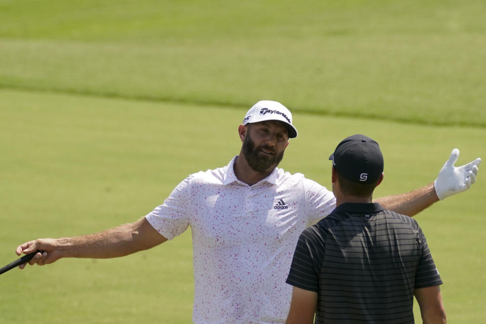 Dustin Johnson and Jordan Spieth talk on the driving range before a practice round for the PGA Championship golf tournament, Wednesday, May 18, 2022, in Tulsa, Okla. (AP Photo/Sue Ogrocki)