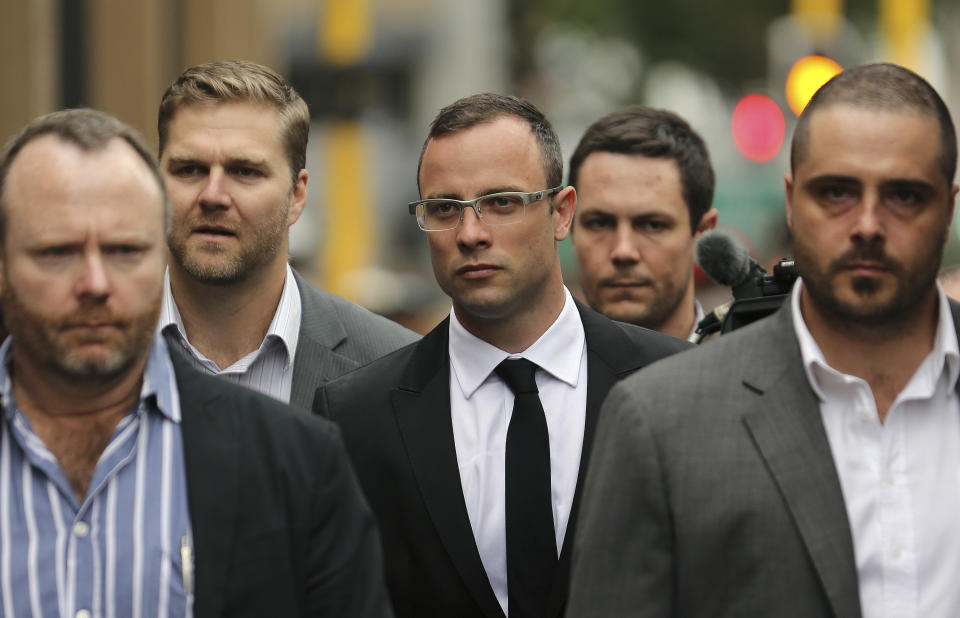 Oscar Pistorius, center, with his relatives arrives at the high court in Pretoria, South Africa, Friday, March 28, 2014. The murder trial of Pistorius, who is charged with murder for the shooting death of his girlfriend, Reeva Steenkamp, on Valentines Day in 2013, has been delayed until April 7 because one of the legal experts who will assist the judge in reaching a verdict is sick, the judge said Friday. (AP Photo/Themba Hadebe)