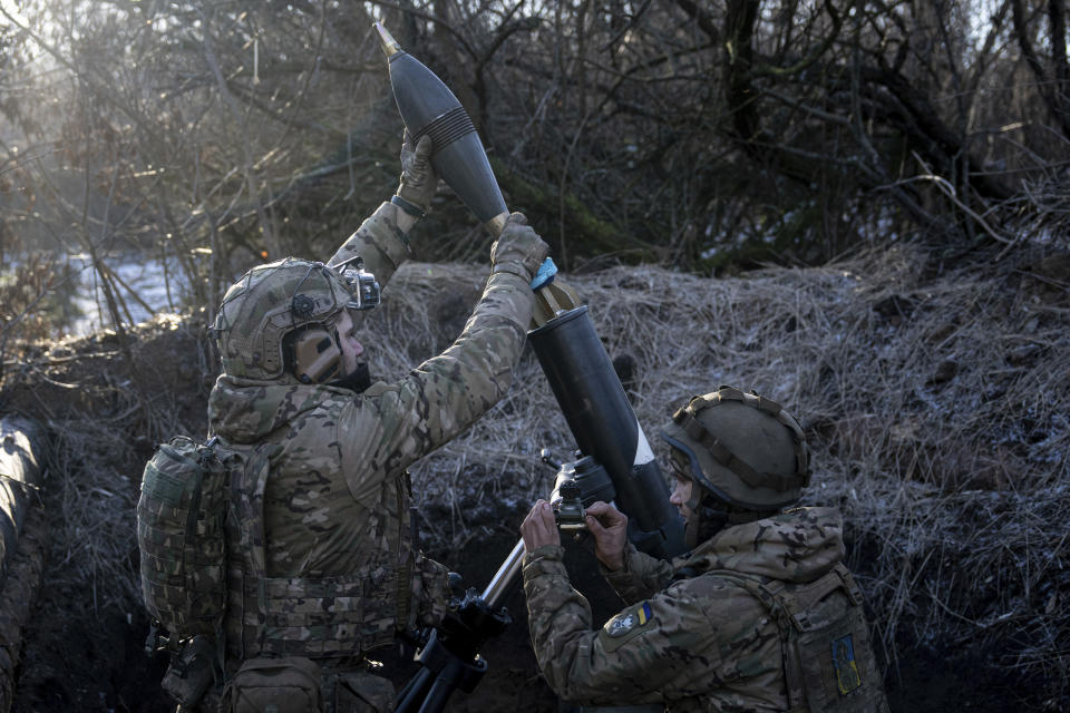 Ukrainian servicemen prepare to fire a 120mm mortar towards Russian position at the frontline near Bakhmut, Donetsk region, Ukraine, Wednesday, Jan. 11, 2023. (AP Photo/Evgeniy Maloletka)