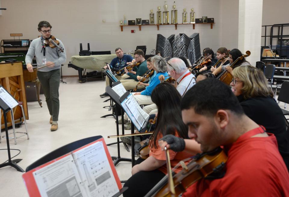 Modern Orchestra teacher Elijah Langille tunes up his musicians before the start of his morning class on Wednesday at Barnstable High School in Hyannis. This is the first year the high school has integrated special needs children into an orchestra class. The class has 20 students, including students with a range of special needs, general enrollment students, and students for whom English is not their primary language.