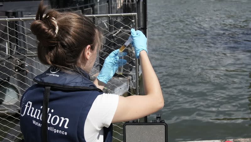 Aurelie Lemaire, a microbiology research intern, uses a reagent to test the Seine river water quality, on Friday, Aug. 4, 2023 in Paris. Heavy rains have set back plans to test Paris’ readiness for swimmers to race in the River Seine at next year’s Summer Olympics. A planned training session Friday for swimmers aiming to compete this weekend in the river that cuts through Paris was canceled because the water quality dropped below acceptable standards, the international governing body of swimming announced.