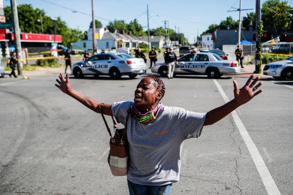 Louisville, Ky., resident Lenora Moore yells, "My mouth is a weapon" at the intersection of 26th and Broadway on June 1 after a man was shot and killed outside Dino's Market.