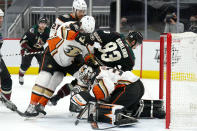 Anaheim Ducks goaltender Ryan Miller (30) makes a save under defenseman Jani Hakanpaa (28), defenseman Cam Fowler (4) and Arizona Coyotes right wing Conor Garland (83) during the second period of an NHL hockey game Wednesday, Feb. 24, 2021, in Glendale, Ariz. (AP Photo/Rick Scuteri)