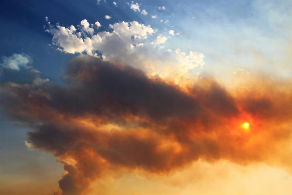 White clouds contrast with smoke colored brown and orange by the sun poking through smoke Tuesday event west of Abilene on Tuesday night.  A southerly wind blew smoke well north of the city, and the fire was only 10% contained as of Wednesday morning.