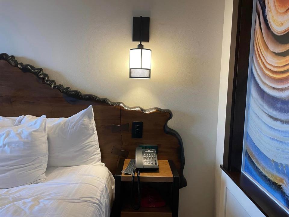 side of a bed with a built in nightstand and wall sconce in a villa at disney's wilderness lodge