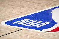 FILE - The NBA logo at center court is shown during the second half of an NBA first-round playoff basketball game between the Houston Rockets and Oklahoma City Thunder in Lake Buena Vista, Fla., Wednesday, Sept. 2, 2020. The NBA has agreed to terms on its new media deal, an 11-year agreement worth $76 billion that assures player salaries will continue rising for the foreseeable future and one that will surely change how some viewers access the game for years to come. (AP Photo/Mark J. Terrill, File)