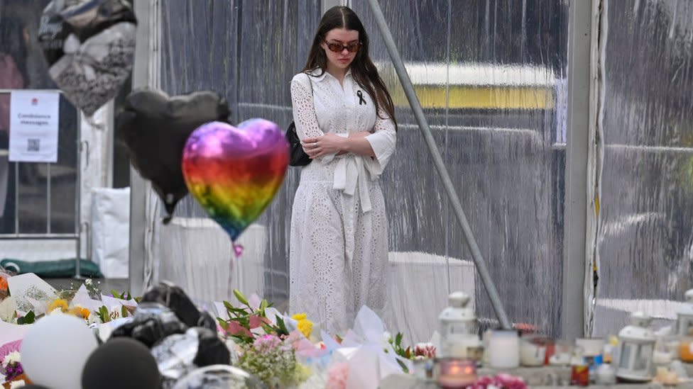 A member of the community visits the flower memorial near the Bondi Junction Westfield